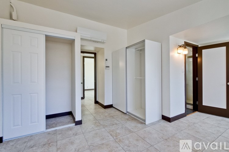 A hallway with a white door on the left and a brown door on the right.