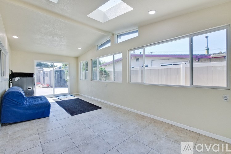 A spacious room with a blue bean bag chair and large windows.