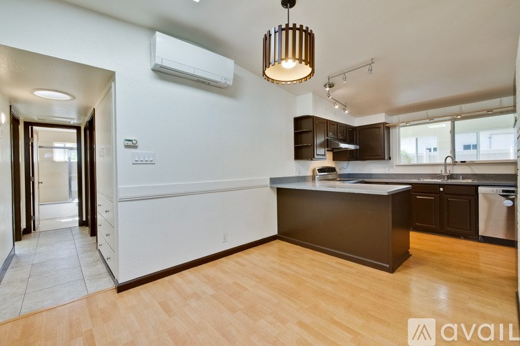 A kitchen with a brown counter and a white wall.