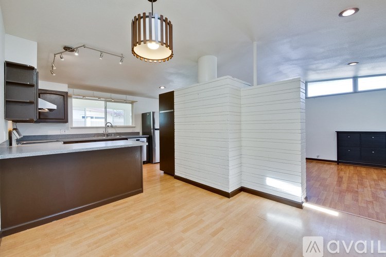 A kitchen with a dark counter and a wooden floor.