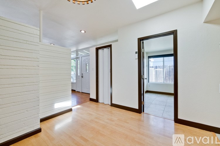A hallway with a wooden floor and white walls.
