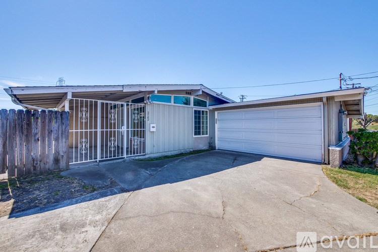 A house with a white garage door and a wooden fence.