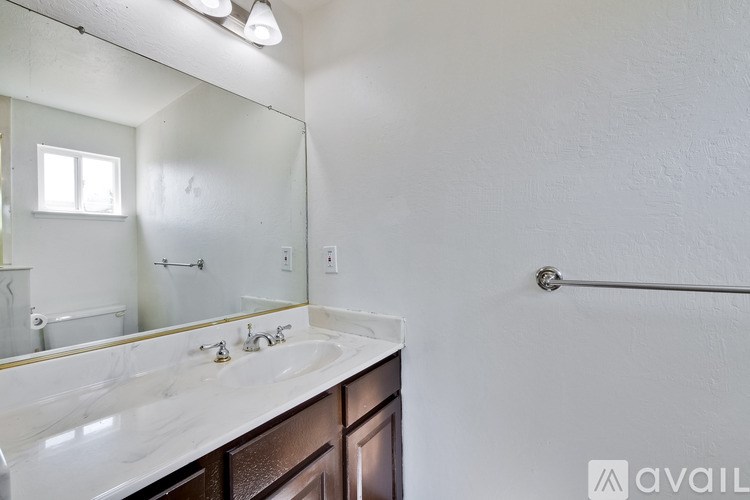 A bathroom with a marble countertop and a large mirror.