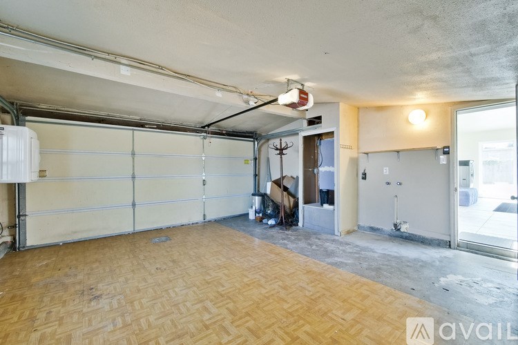 A room with a wooden floor and a garage door.
