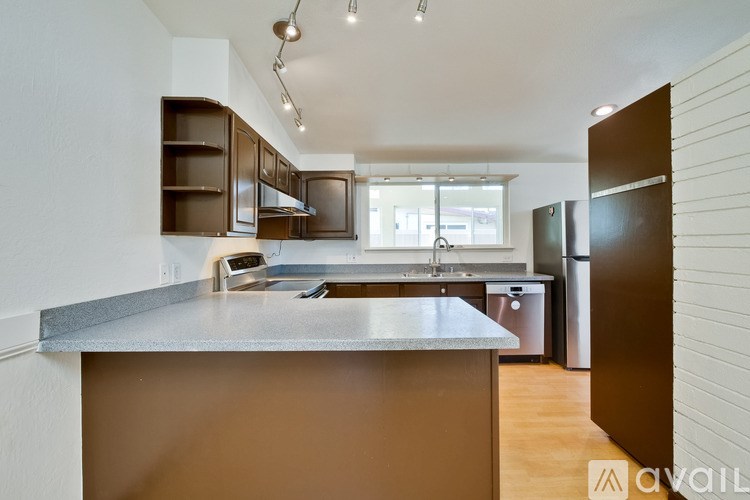 A kitchen with a brown countertop and stainless steel appliances.