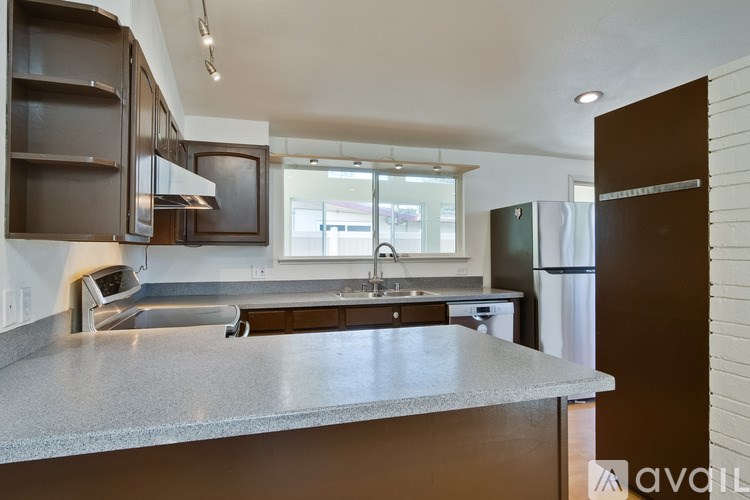 A kitchen with brown cabinets and a granite countertop.
