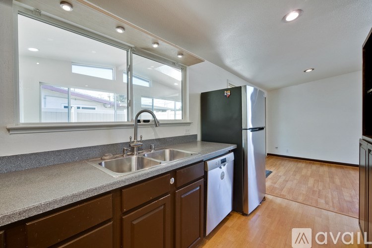 A kitchen with brown cabinets and a stainless steel refrigerator.