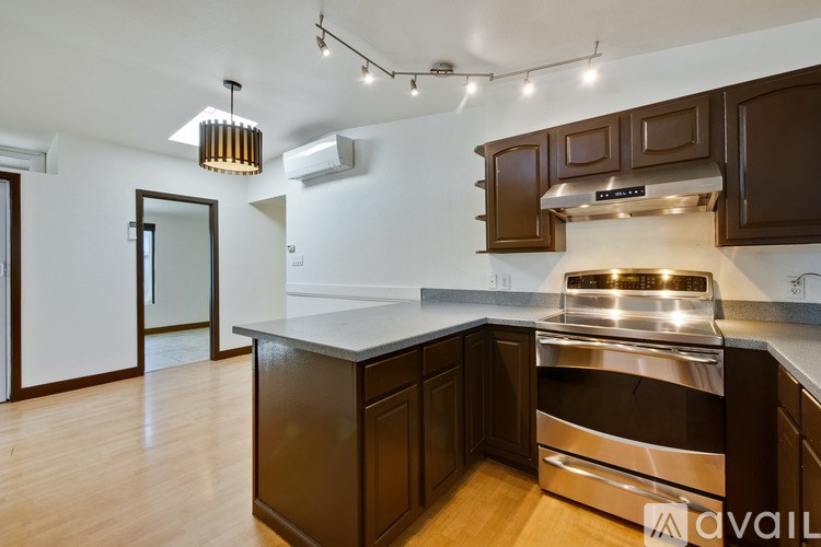 A kitchen with brown cabinets and a stainless steel oven.