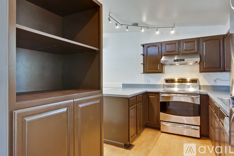 A kitchen with brown cabinets and a stainless steel oven.