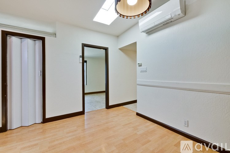 A room with a wooden floor and a mirror on the wall.