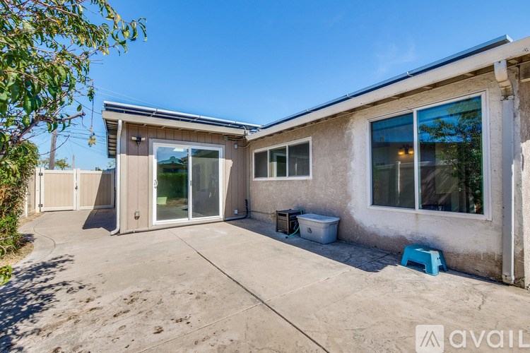A house with a patio and a blue stool is available for rent.