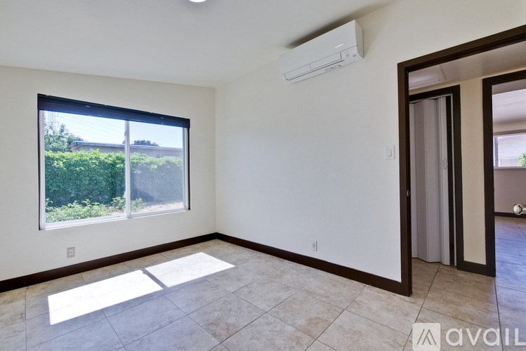 A room with a window and a door is available for rent.