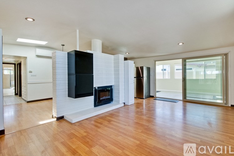 A modern living room with a fireplace and wooden floors.