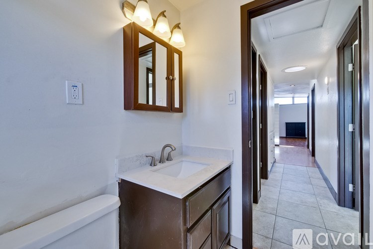 A bathroom with a white sink and a mirror above it.