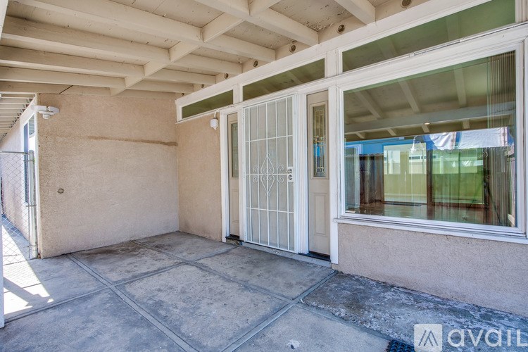 A patio area with a sliding glass door and a concrete floor.