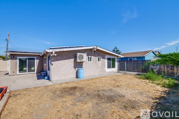 A house with a blue container in front of it.