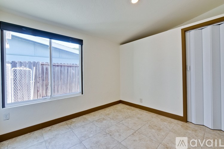 A room with a window and a tiled floor is available for rent.