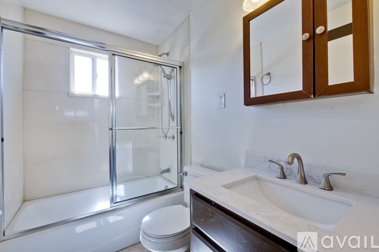 A bathroom with a toilet, sink, and shower.