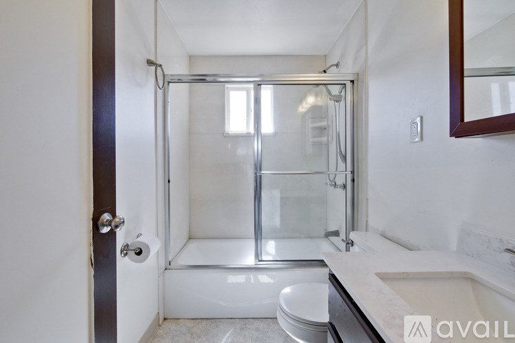 A bathroom with a toilet, sink, and walk-in shower.