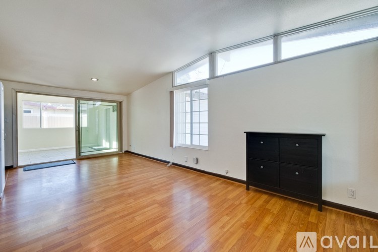 A room with wooden floors and a black dresser.