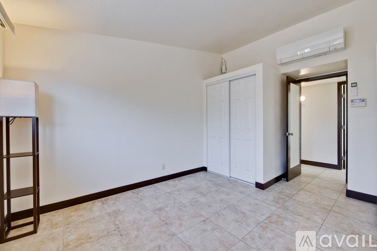A room with a white door and a tiled floor.