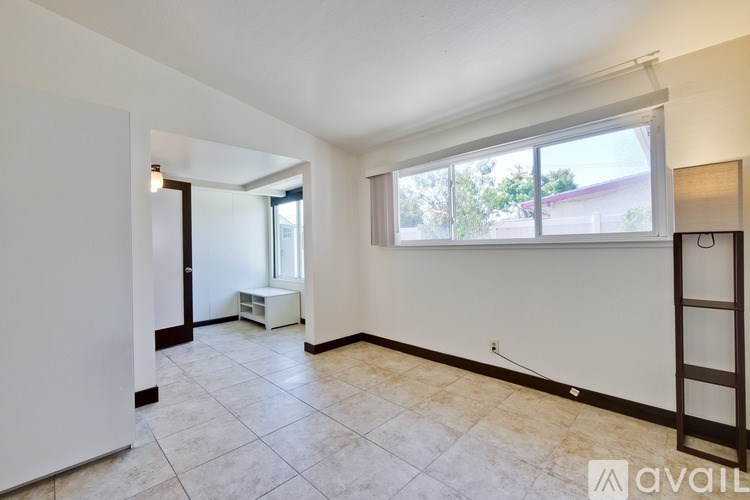 A room with a ladder and a window with blinds.