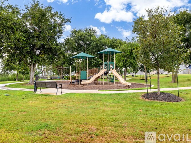 A playground with a green slide and a canopy.