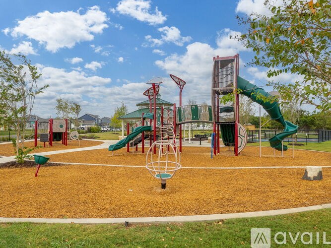 A playground with a red and green slide and a green and red climbing frame.