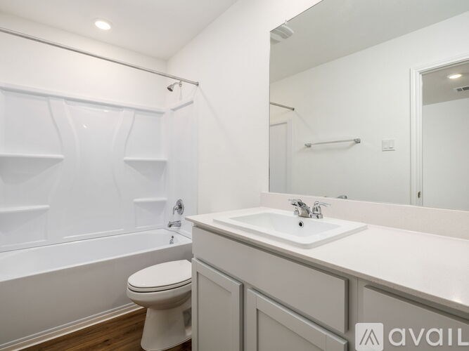 A white bathroom with a toilet, sink, and bathtub.