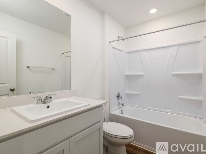 A white bathroom with a sink, toilet and bathtub.