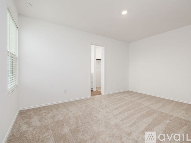 A room with a carpeted floor and a doorway leading to another room.
