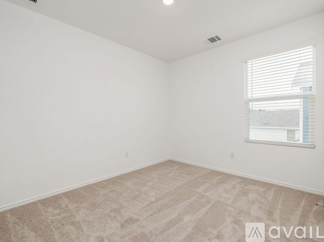 Empty room with carpeted floor and a window.