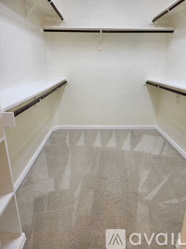 A room with white walls and a carpeted floor with a logo on it.