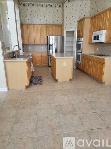 A kitchen with wooden cabinets and a tile floor.