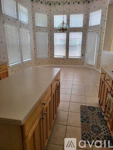 A kitchen with wooden cabinets and a tiled floor.
