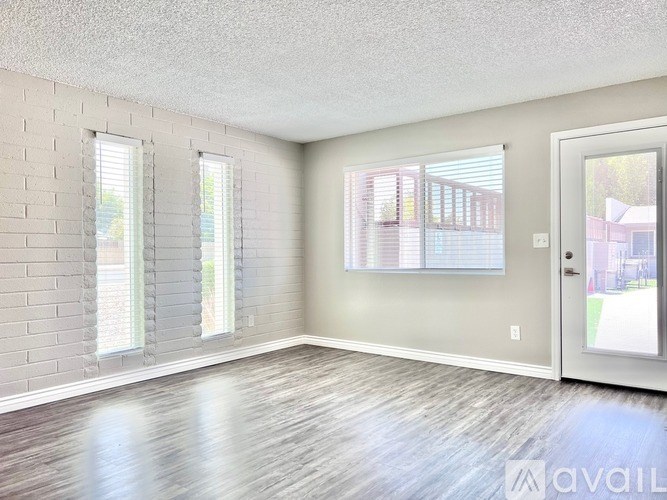 A room with a door, two windows, and a brick wall.