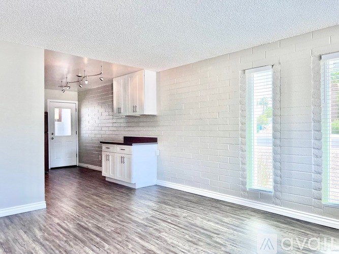 A kitchen with white cabinets and a white refrigerator.