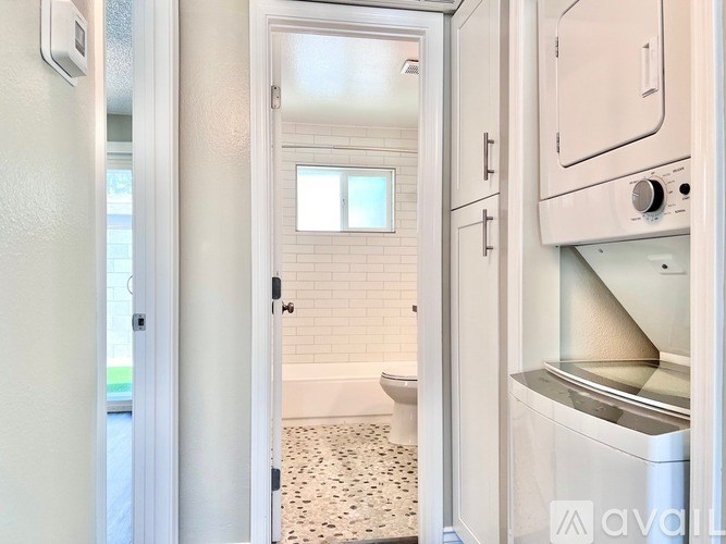 A white bathroom with a toilet, sink, and a window.