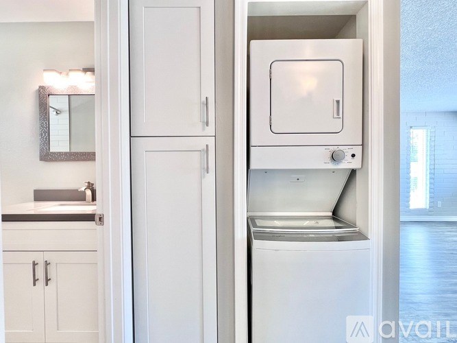 A white kitchen with a dishwasher and a mirror cabinet.