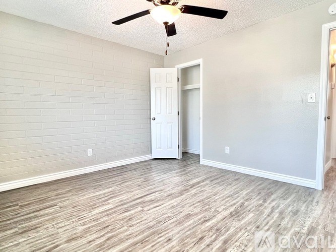 A room with a ceiling fan and a door.