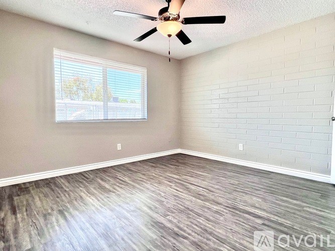 A room with a ceiling fan and a window with blinds.