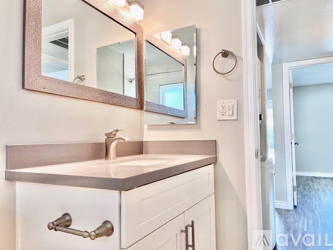 A bathroom with a sink, mirror, and light switch.