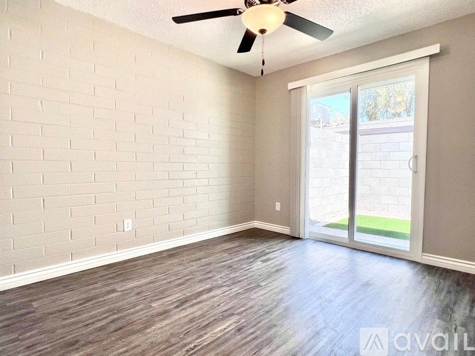 A room with a ceiling fan and sliding glass doors.