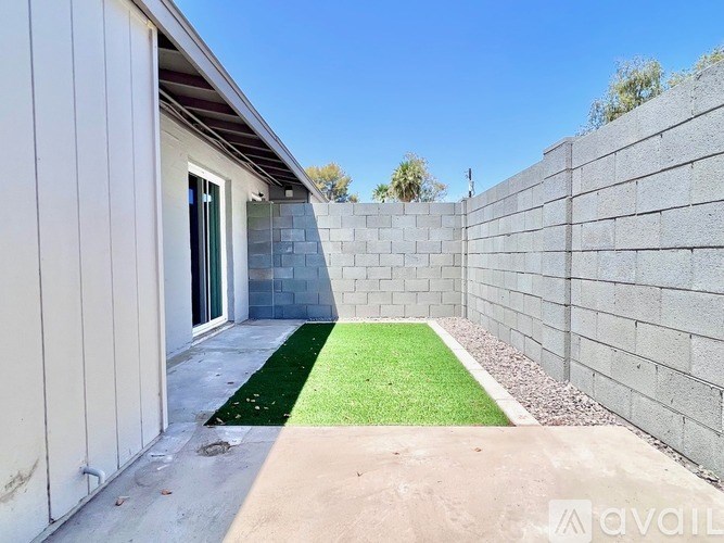 A concrete wall with a small patch of green grass in the middle.