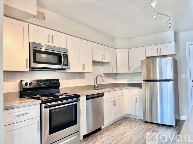 A kitchen with white cabinets and stainless steel appliances.