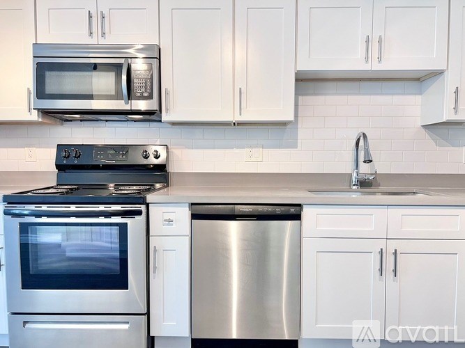 A kitchen with white cabinets and stainless steel appliances.