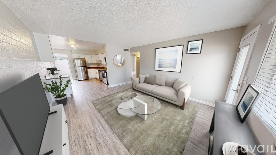 A living room with a couch, coffee table, and a television.