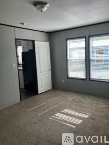 A room with a white door and a window with blinds.