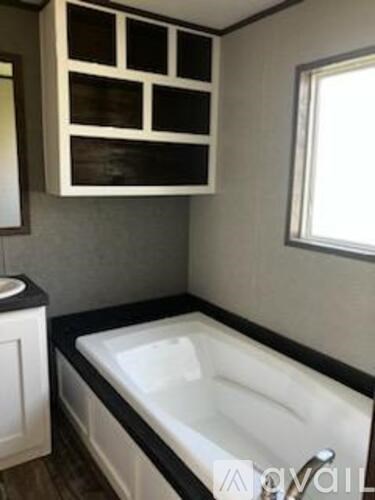 A white bathtub with a black border sits in a bathroom.