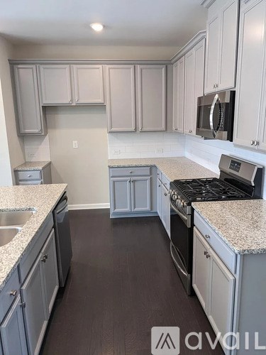 A kitchen with white cabinets and a granite countertop.
